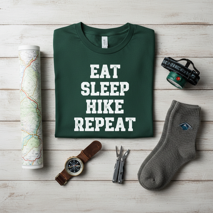 Overhead flat lay of folded eat sleep hike repeat t-shirt with trail map